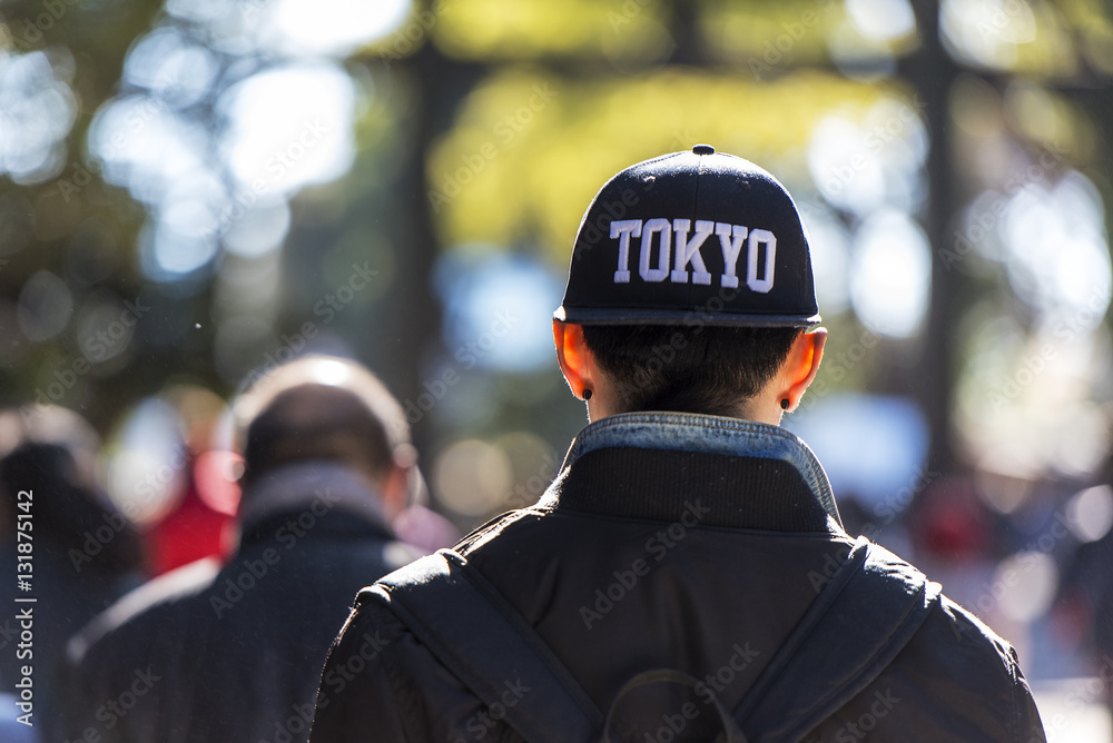 Fototapeta premium A young man dressed in fashion cap going in a park in Tokyo Japan