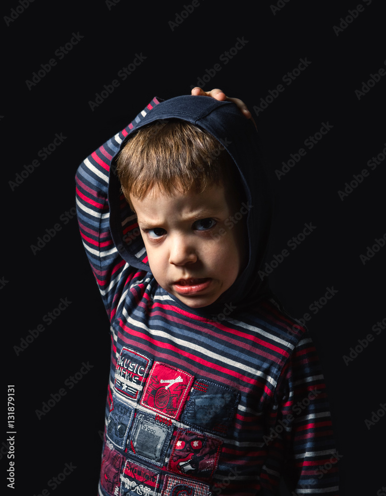 Portrait of angry with hoodie looking at camera over a black background Portrait of angry with hoodie looking at camera over a black background