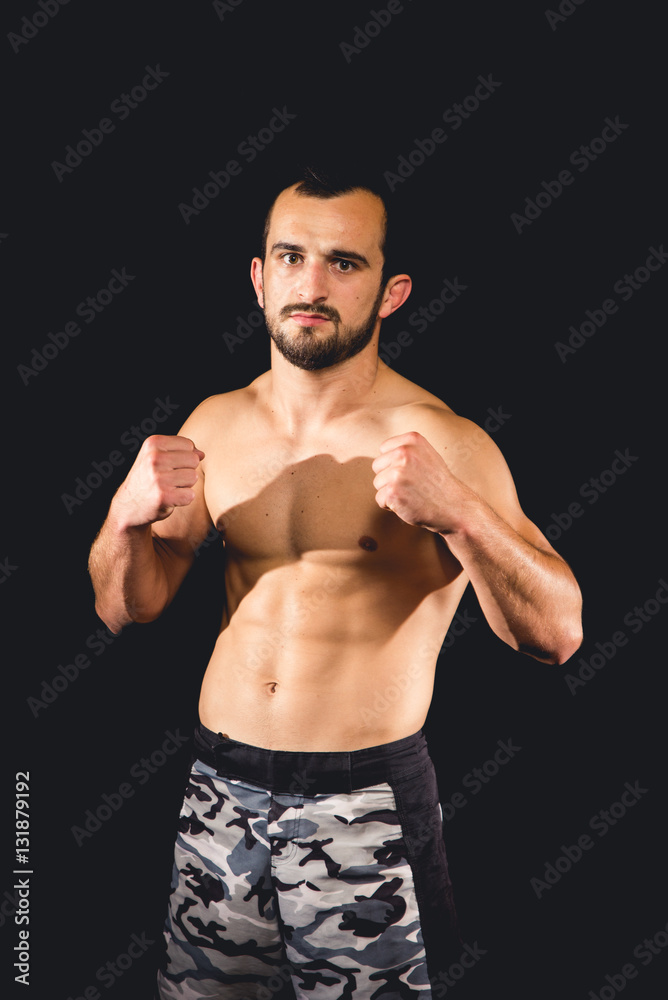 Athlete standing in a boxing guard isolated with a dark background