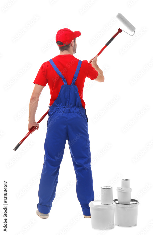 Handsome young decorator painting white wall Handsome young decorator painting white wall