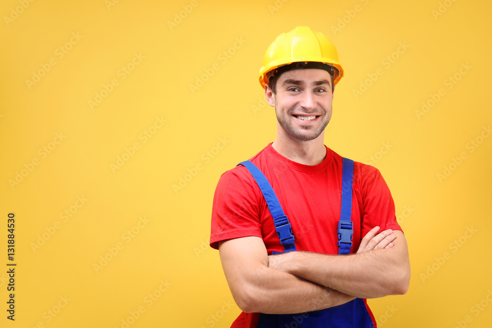 Handsome young worker on yellow background