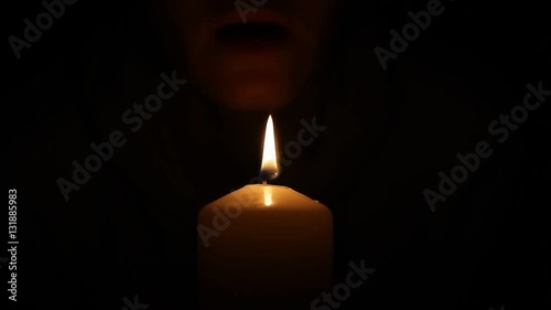 Woman blows out the candle in the dark
