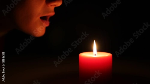 Woman blows out the candle in the dark
