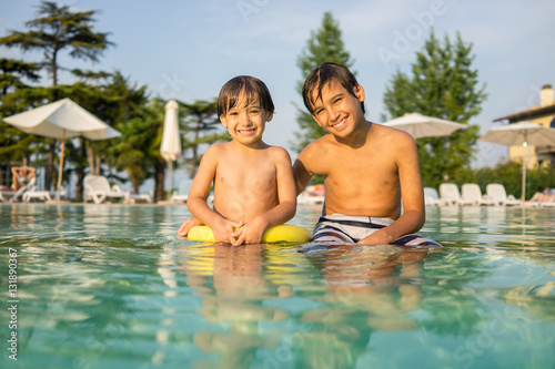 Young boy kid child splashing in swimming pool having fun leisur