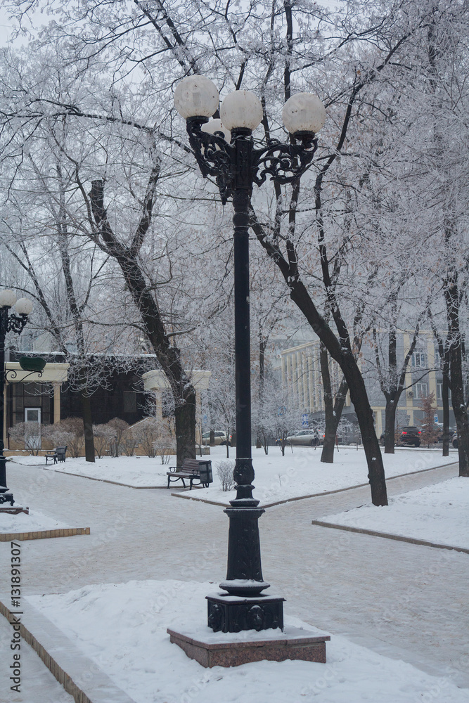 Retro lantern on a snowy city boulevard. Urban