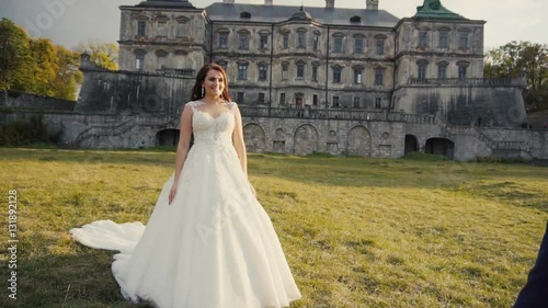 First look of young wedding couple, bride and groom, meeting before old castle, slowmotion 120 fps photo