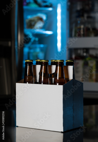 Fotografie Six pack of brown beer bottles on kitchen counter
