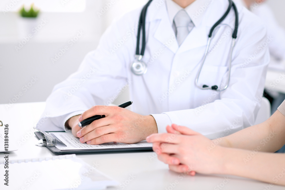 Doctor and patient are discussing something, just hands at the table Doctor and patient are discussing something, just hands at the table