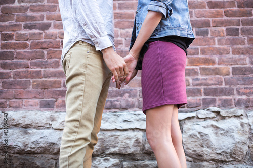 Holding Hands in front of brick wall