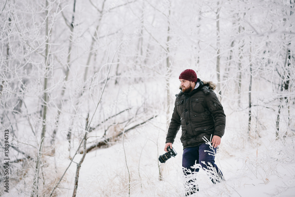 Traveler photographer taking pictures in the winter forest