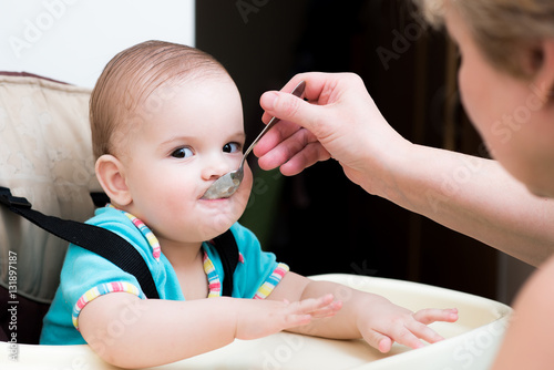 mother feeding her baby breast porridge day