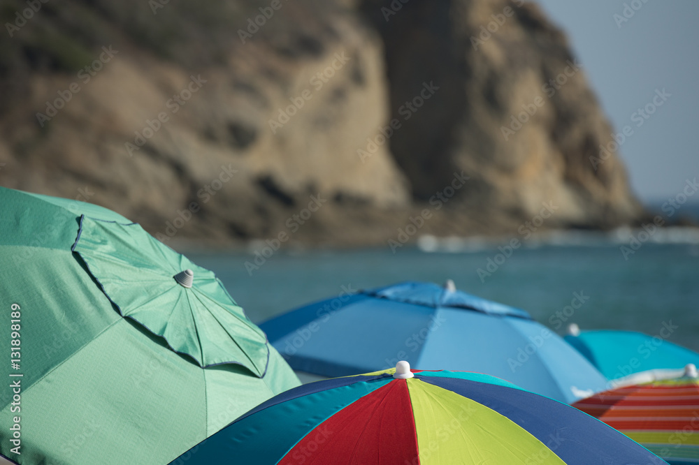 beach umbrellas with sea cliffs and ocean in background