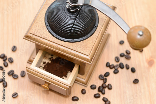 Photo of coffee grinder on wooden background.