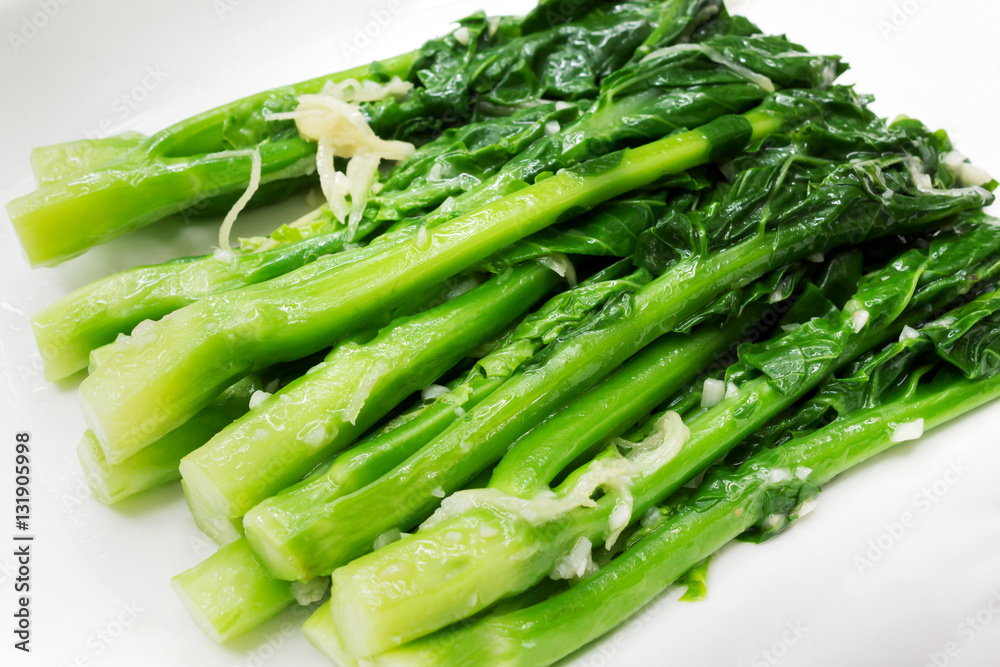 Vegetarian food, Chinese style fried kale with garlic on white p Vegetarian food, Chinese style fried kale with garlic on white p