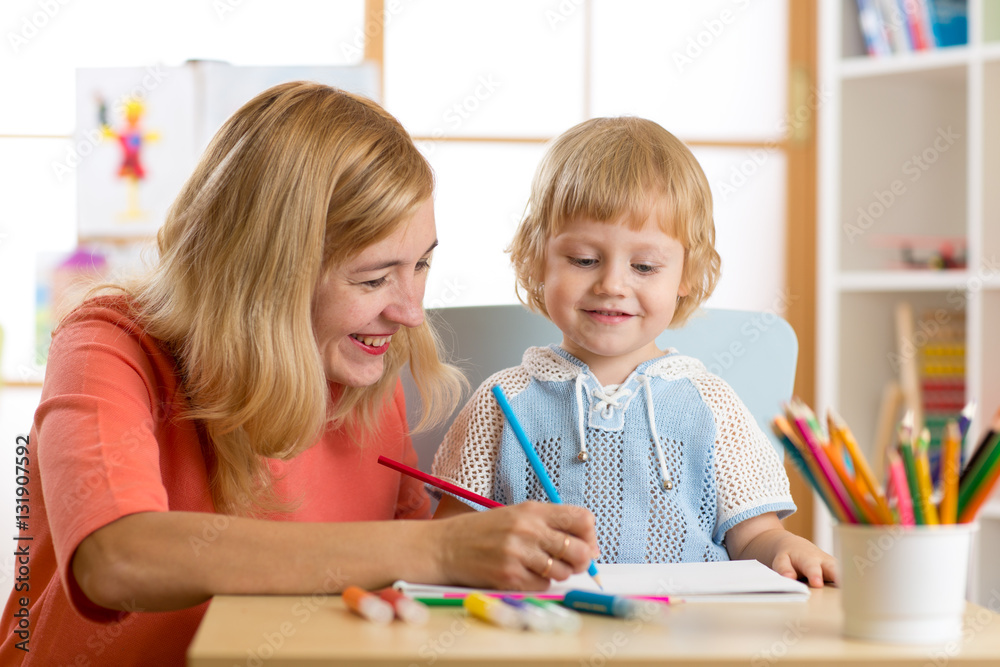 Happy family - mother and son toddler together paint. Adult woman helps to child boy. Happy family - mother and son toddler together paint. Adult woman helps to child boy.