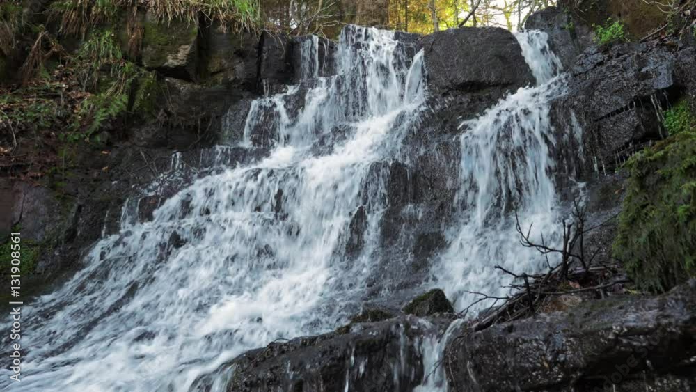 Cleddon Falls waterfall on the River Wye is a designated Area of Natural Beauty (AONB ) in Wales in the UK. Water cascades over layers of rock on an overcast day. Cleddon Falls waterfall on the River Wye is a designated Area of Natural Beauty (AONB ) in Wales in the UK. Water cascades over layers of rock on an overcast day.
