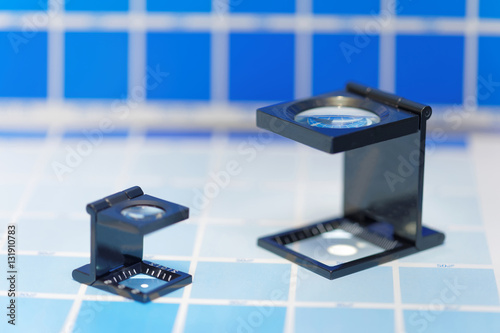 Two magnifier or printer's loupe sits on a cyan test sheet