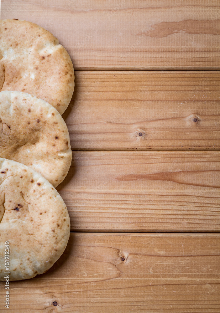 Pita, Arabic bread, wooden background, free text space Pita, Arabic bread, wooden background, free text space