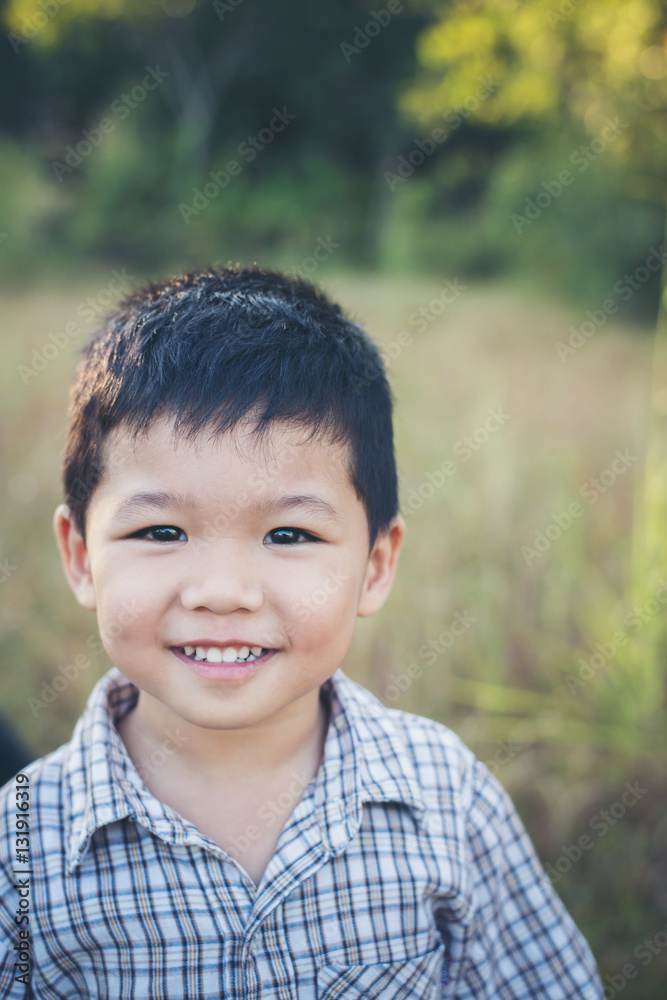Close up of cute asian boy playing and smiling outdoors. Cute li Close up of cute asian boy playing and smiling outdoors. Cute li