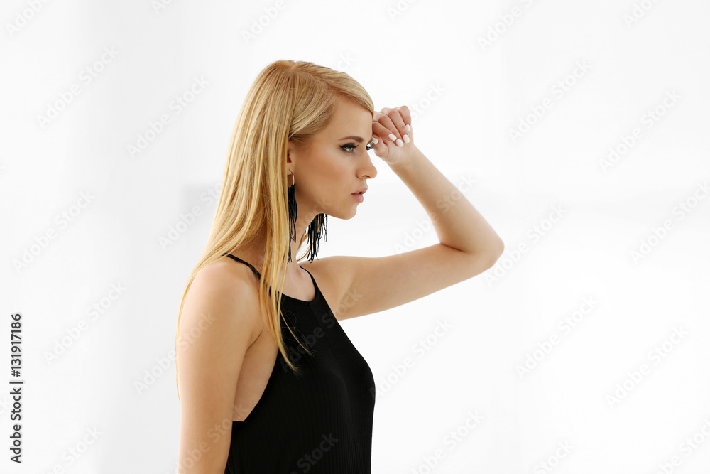 Pretty young blonde woman against light background