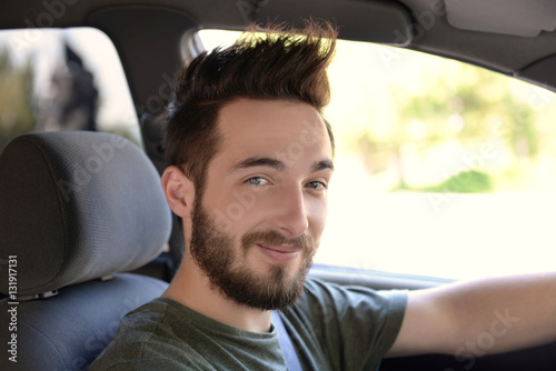 Portrait of successful young man sitting in car