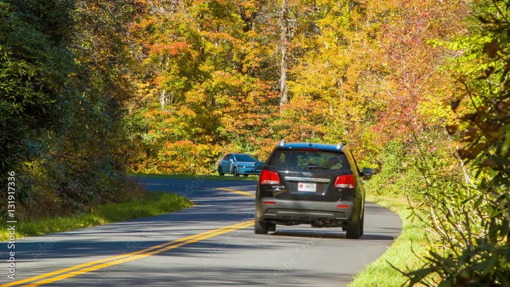 Cars Driving on the Scenic Blue Ridge Parkway with Fall Colored Leaves in the Smoky Mountains of Western North Carolina on a Sunny Day Cars Driving on the Scenic Blue Ridge Parkway with Fall Colored Leaves in the Smoky Mountains of Western North Carolina on a Sunny Day