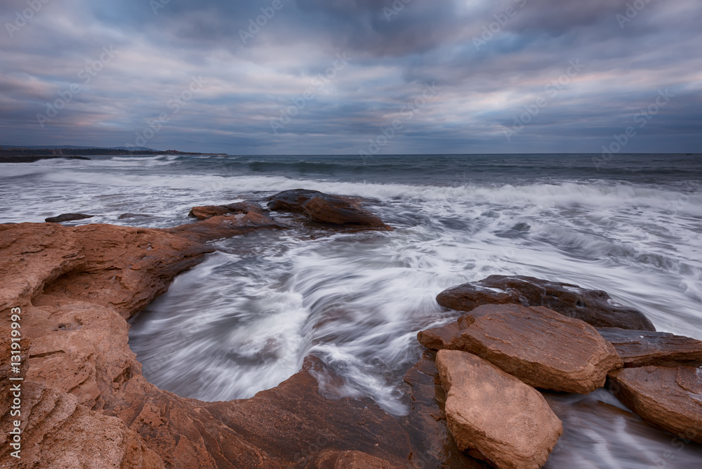 Obraz premium Cloudy dramatic sky, big waves, cloudscape just before the storm near the shore