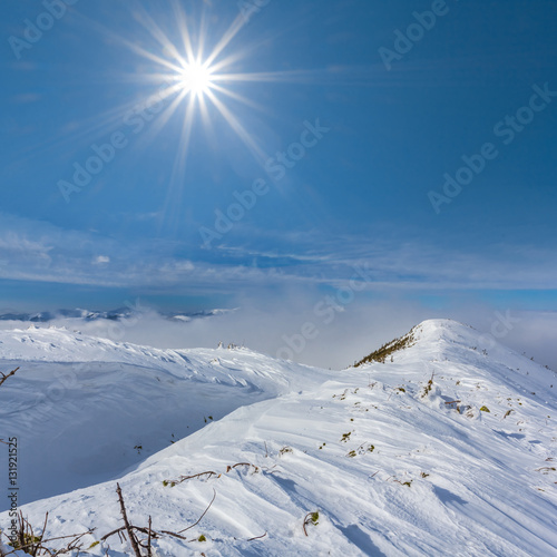 snowbound mountain ridge under a sparkle sun