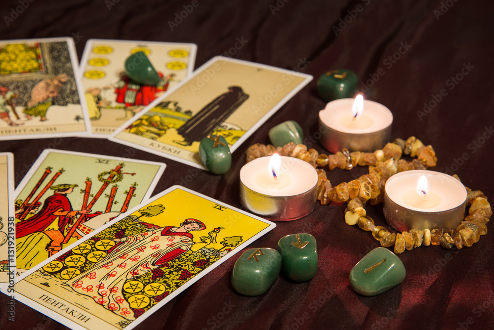 Tarot cards with runes and burning candle