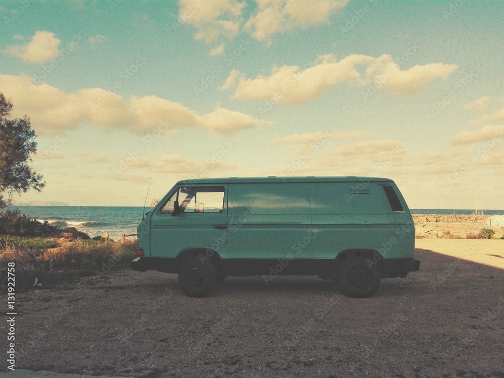 Old van parked next to the beach
