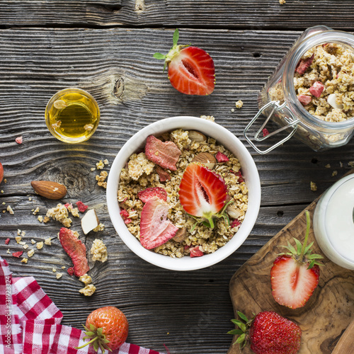 Healthy breakfast. Strawberry granola with almond petals and fresh berries. Served  milk, honey  mint. Top view