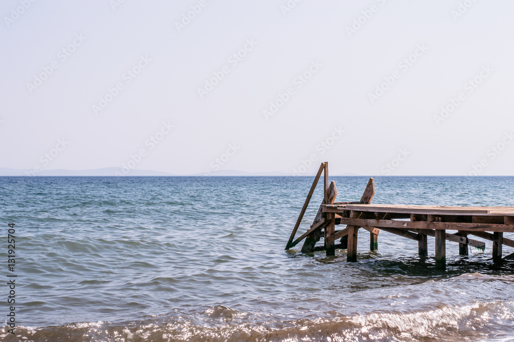 View of a wooden pier and seascape with running waves View of a wooden pier and seascape with running waves