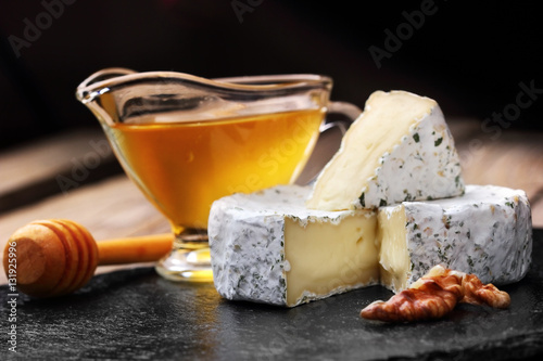 Camembert cheese with nuts on spoon for honey and honey dark slate background.copy space.selective focus