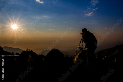 silhouette of photographer taking photo at sunrise in a beautifu