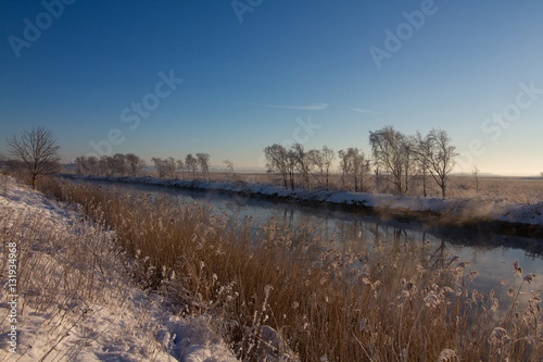 Winter landscape with snow, ocean, sea, blue sky, road, sunshine, ice.