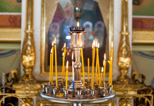 Church candles standing in the temple on the stand during the service. Religious Orthodoxy and Catholicism symbol.