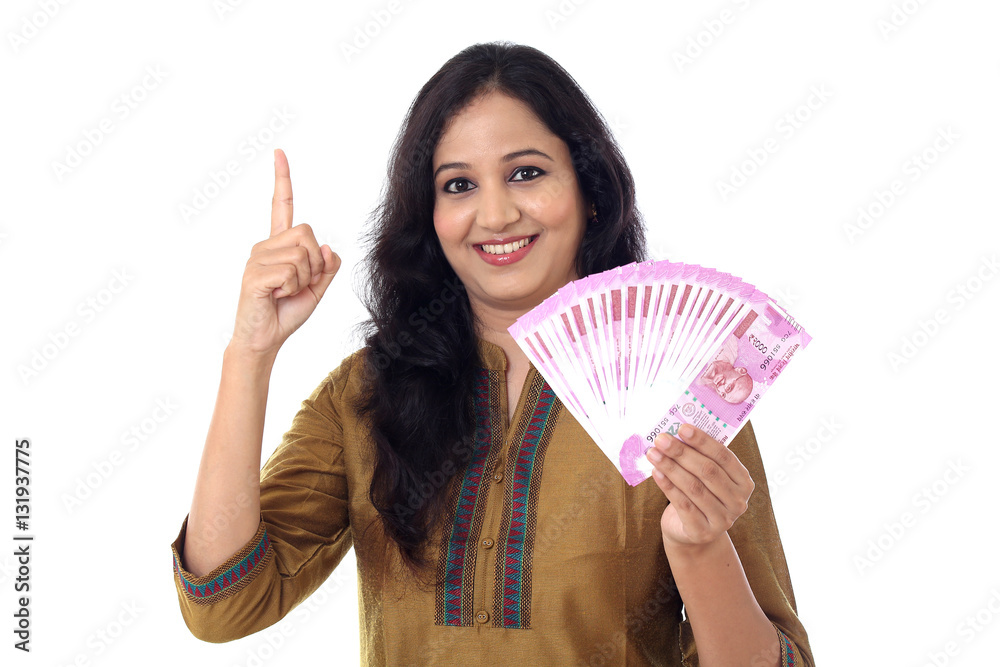 Happy young woman holding 2000 rupee notes against white Happy young woman holding 2000 rupee notes against white