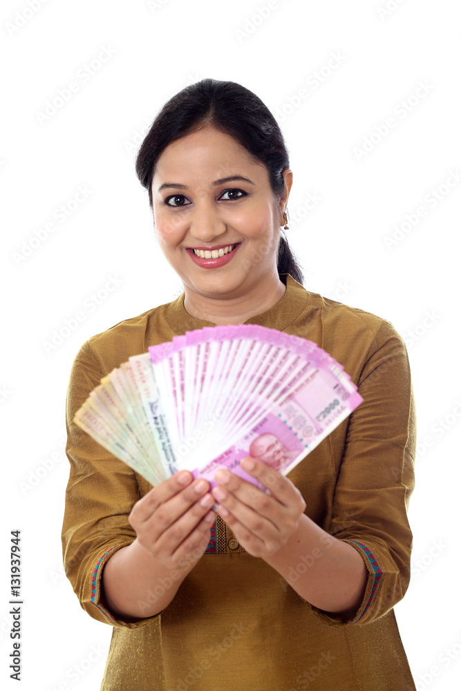 Happy young woman holding 2000 and 100 rupee notes Happy young woman holding 2000 and 100 rupee notes