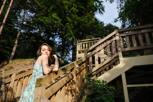 girl sitting on the wooden stairs in park and smiling