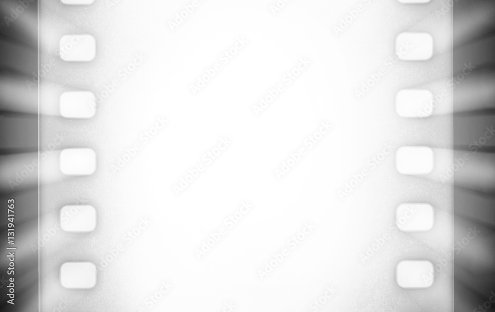 Fototapeta premium Black and white cinema film strips and projector light rays.