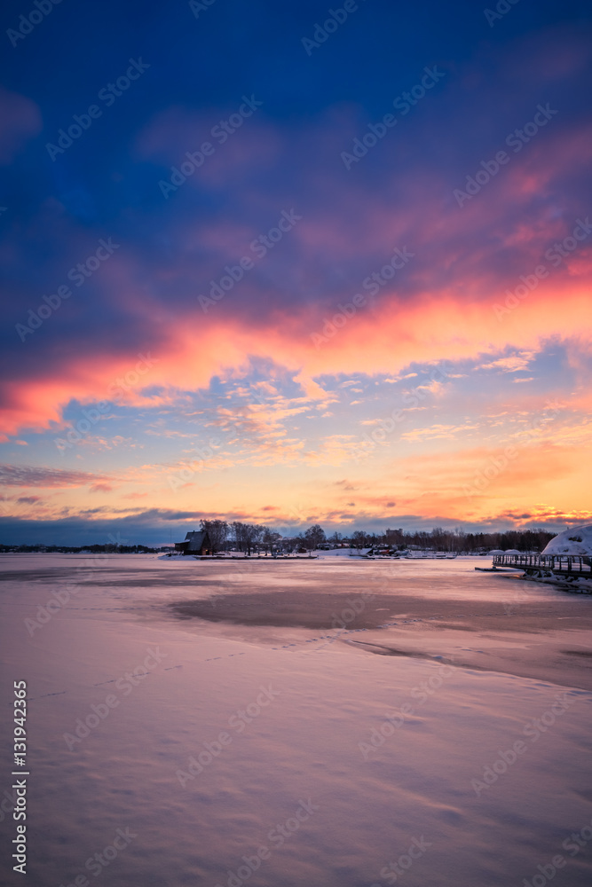 View of a frozen lake during sunrise in winter season.
Location: Ramsey Lake, Ontario, Canada