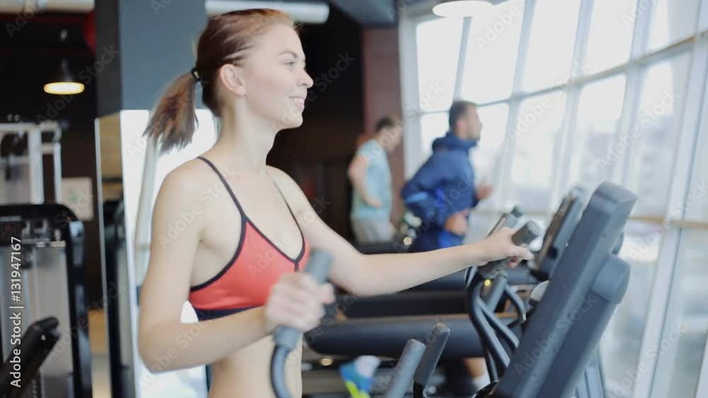 Sporty girl running on running exercise machine in modern at gym Sporty girl running on running exercise machine in modern at gym