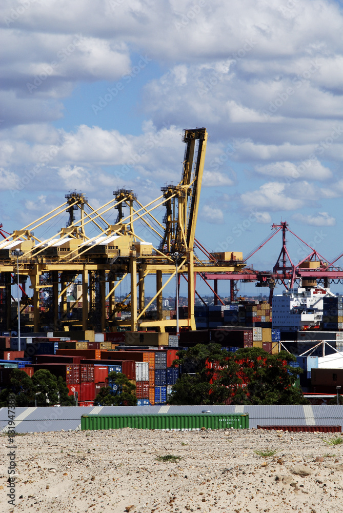 Stradle cranes working container port terminal clouds.
