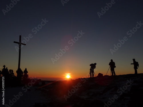  Silhouette of photograph is taking some photograph on mountain. A Crucifix In Front Of A Sky.