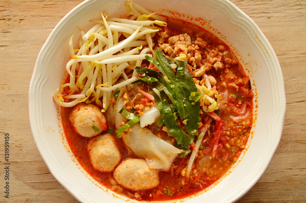 large noodle with pork ball in tom yum spicy soup topping fresh bean sprout on bowl