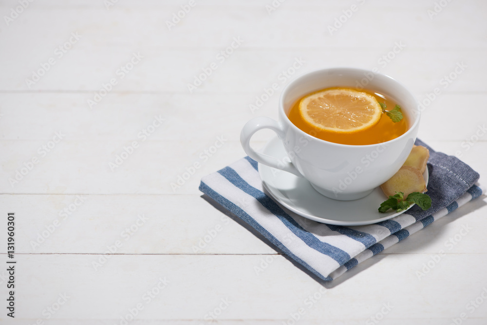 Cup of Ginger Tea with Lemon and Honey on a White Wooden Backgro