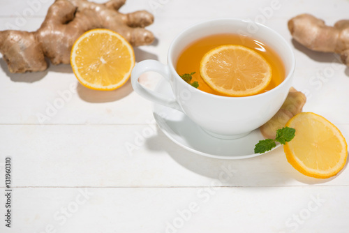 Cup of Ginger Tea with Lemon and Honey on a White Wooden Backgro
