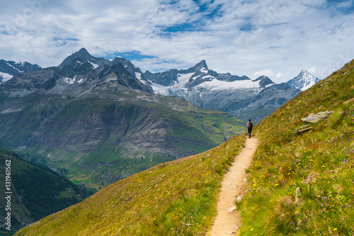 Girl walking on spectacular mountain scenery, Alps, Switzerland.