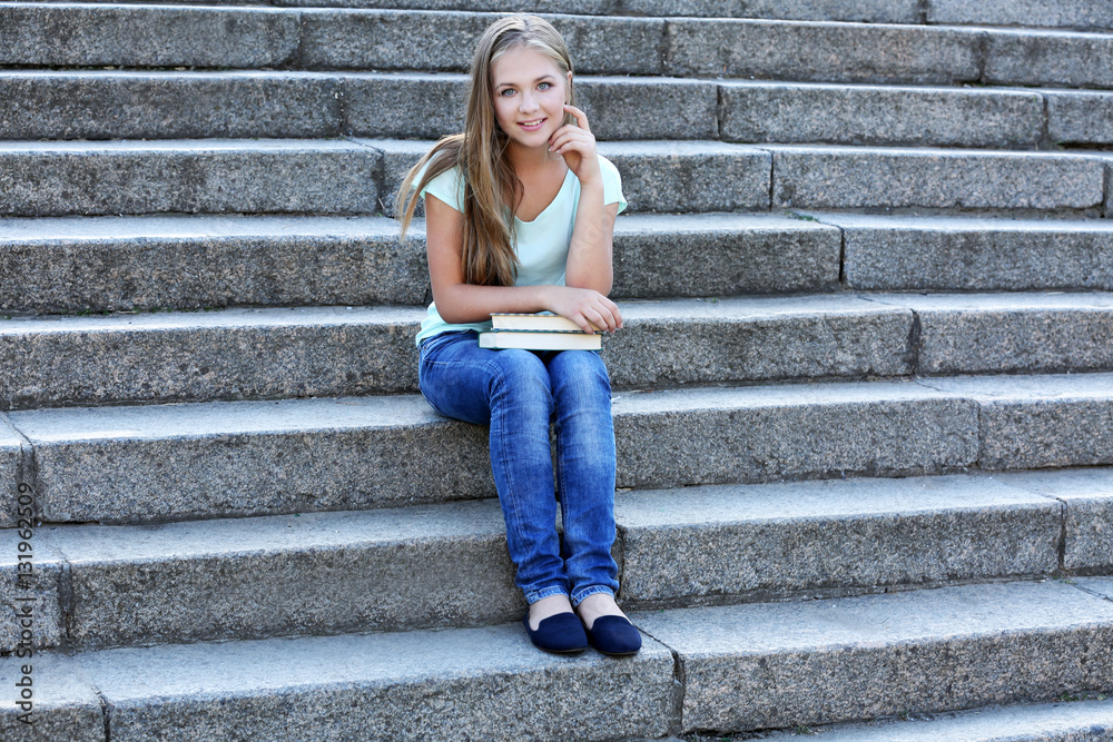 Pretty teenager girl sitting on stairs outdoors Pretty teenager girl sitting on stairs outdoors