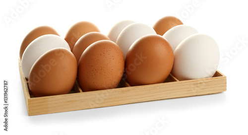Wooden stand with raw eggs on white background